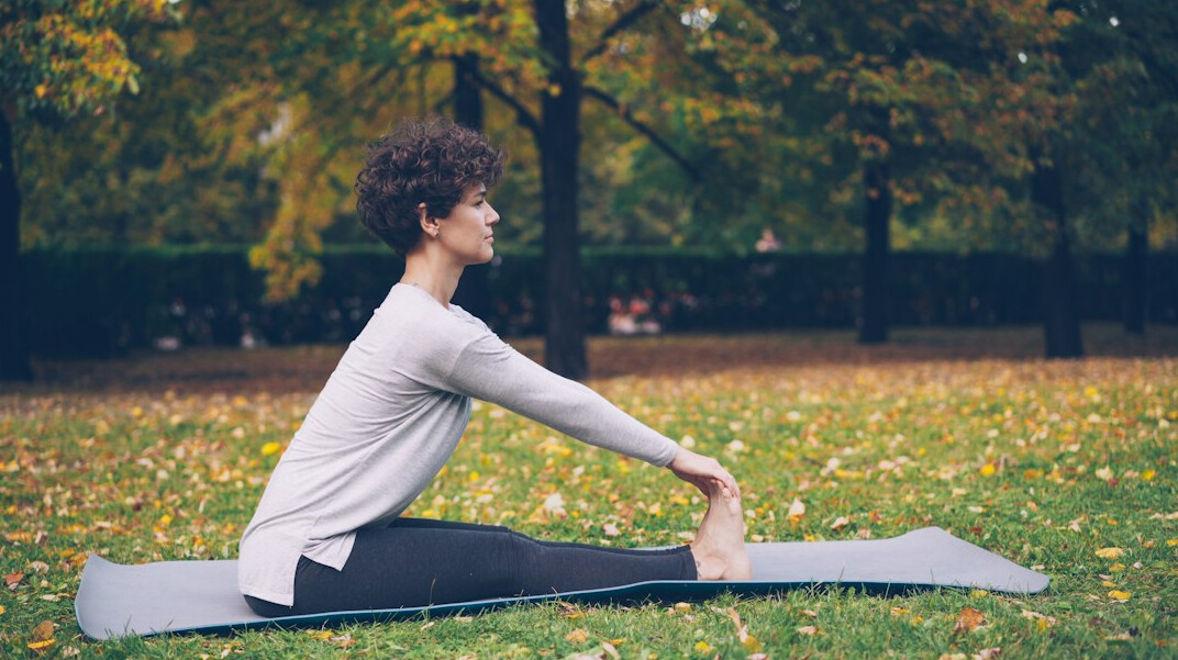 senior doing yoga in park